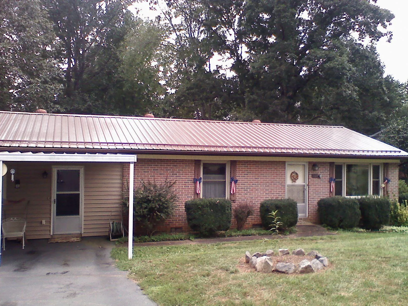 Bronze metal roof and carport on a brick ranch home — Roof Repair work by our crew in Ontario